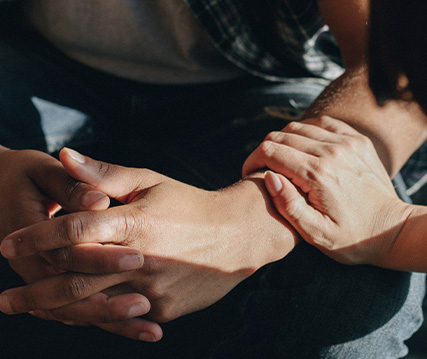 smiling older man demonstrating a device to a woman seated at a table engaging in helpful discussions about health and wellness tools for seniors